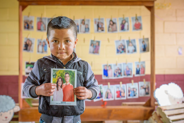 Little boy holds photo of his new Chosen sponsors.