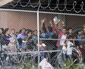 FILE - In this March 27, 2019, file photo, Central American migrants wait for food in a pen erected by U.S. Customs and Border Protection to process a surge of migrant families and unaccompanied minors in El Paso, Texas.