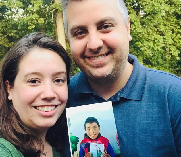 Alana Gillett holding up picture of Chosen child sponsor