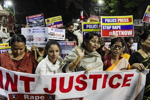 Volunteers of a social and non-government organization walk with posters during a protest demanding justice in the case of a veterinarian who was gang-raped and killed last week, in Kolkata, India, Wednesday, Dec. 4, 2019.