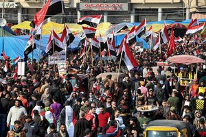 Hundreds of people march inside Tahrir Square carrying national flags and chanting religious slogans in Baghdad, Iraq, Thursday, Dec. 5, 2019.