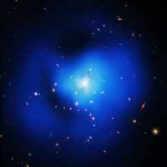 File - Galaxy clusters are often described by superlatives. After all, they are huge conglomerations of galaxies, hot gas, and dark matter and represent the largest structures in the Universe held together by gravity. New data provide more details on how the galaxy cluster SPT-CLJ2344-4243, nicknamed the Phoenix Cluster for the constellation in which it is found, challenges this trend.