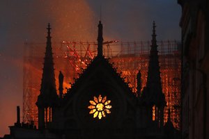 Flames and smoke rise from Notre Dame cathedral as it burns in Paris, Monday, April 15, 2019. Massive plumes of yellow brown smoke is filling the air above Notre Dame Cathedral and ash is falling on tourists and others around the island that marks the center of Paris. (AP Photo/Thibault Camus)