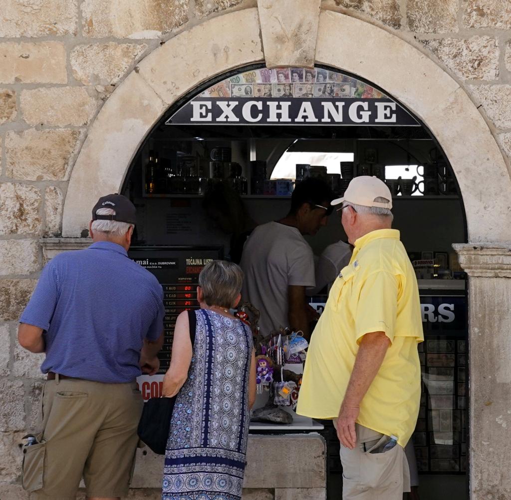 In der Altstadt von Dubrovnik warten Touristen vor einer Wechselstube