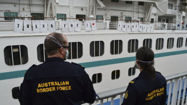 Australian Border Force officers watch the Artania as it departs Fremantle. 