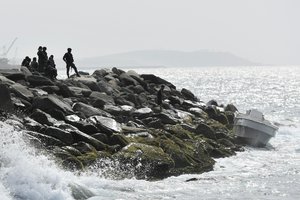 Security forces guard the shore area and a boat in which authorities claim a group of armed men landed in the port city of La Guaira, Venezuela, Sunday, May 3, 2020. Interior Minister Nestor Reverol said on state television that security forces overcame before dawn Sunday an armed maritime incursion with speedboats from neighboring Colombia in which several attackers were killed and others detained.