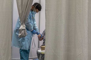 Army Pvt. Joshua Rodriguez, a combat medical specialist assigned to the Javits New York Medical Station, checks a patient’s pulse in New York, Apr. 8, 2020, while supporting Coronavirus COVID-19 response efforts in the area.