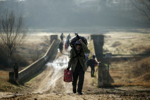 Migrants walk to enter Greece from Turkey by crossing the Maritsa river (Evros river in Greek) near the Pazarkule border gate in Edirne, Turkey, Sunday, March. 1, 2020.