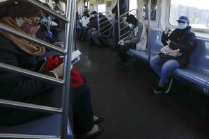 Riders wear protective masks as they take a 7 train, Wednesday, May 13, 2020, in the Queens borough of New York.