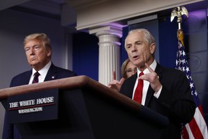 White House trade adviser Peter Navarro, who will now serve as national defense production act policy coordinator, speaks about the coronavirus in the James Brady Press Briefing Room, Friday, March 27, 2020, in Washington, as President Donald Trump listens.