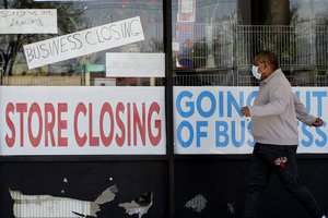 A man looks at signs of a closed store due to COVID-19 in Niles, Ill., Thursday, May 21, 2020. More than 2.4 million people applied for U.S. unemployment benefits last week in the latest wave of layoffs from the viral outbreak that triggered widespread business shutdowns.