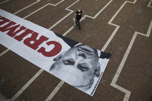 File - A woman walks at the start of a protest against Israeli Prime Minister Benjamin Netanyahu in Tel Aviv, Israel, Sunday, April 19, 2020. The demonstrators accused Netanyahu of using the coronavirus crisis as cover to undermine the country's democratic institutions.