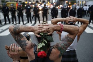 Protesters kneel in front of New York City Police Department officers before being arrested for violating curfew beside the iconic Plaza Hotel on 59th Street, Wednesday, June 3, 2020, in New York. Protests continued following the death of George Floyd.