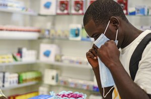 A man tries on a facemask at a pharmacy in Kitwe, Zambia