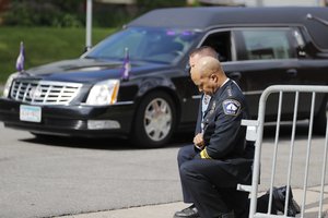 In this June 4, 2020, file photo, police officers including Minneapolis Police Chief Medaria Arradondo, foreground, take a knee as the body of George Floyd arrives before his memorial services in Minneapolis.