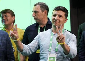 File - Ukrainian President Volodymyr Zelenskiy, right, gestures while speaking at his party's headquarters after a parliamentary election in Kiev, Ukraine, Sunday, July 21, 2019.