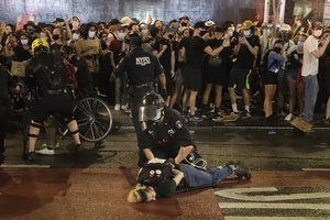 Police arrest protesters as they march along a street in the Manhattan borough of New York, after a curfew went into effect Wednesday, June 3, 2020.