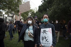 A Japanese-American protestor standing in solidary in Oakland over the death of George Floyd