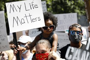 Alex Smith, 3, sits on his mother's, Maya Teeuwissen, shoulders during a rally and march in downtown Jackson, Miss., in response to the recent death of George Floyd, and to highlight police brutality nationwide including Mississippi, Saturday, June 6, 2020.