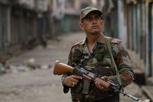 An Indian army soldier stands guard during a curfew imposed following deadly clashes between Hindus and Muslims at Muzaffarnagar in Uttar Pradesh state, India, Monday, Sept. 9, 2013.