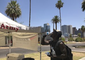 File - Ivan McCarthy, 43, a homeless man, guzzles cold water at a Salvation Army cooling station in downtown Phoenix, Thursday, July 5, 2018. Phoenix's dry heat became a deadly heat Thursday as the National Weather Service issued an excessive heat warning for the area, with temperatures projected to hit 114 degrees Fahrenheit, the highest of the year so far.