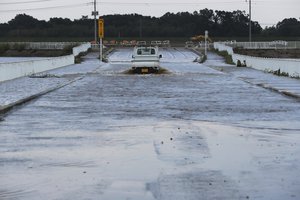 File - A truck drives through a typhoon-flooded street Monday, Oct. 14, 2019, in Kawagoe City, Japan. Rescue crews are digging through mudslides and searching near swollen rivers for missing people after Typhoon Hagibis caused serious damage in central and northern Japan.