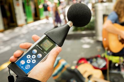 Person checking sound level of buskers playing music