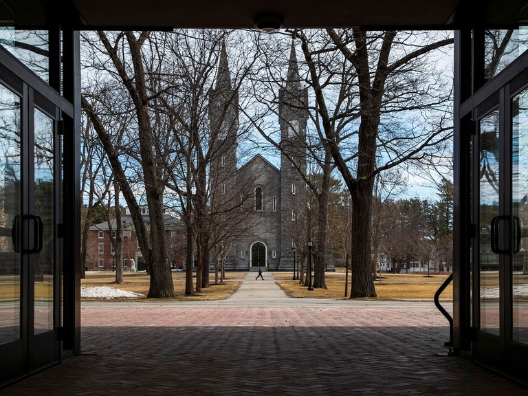 One person walks across a quad at Bowdoin.