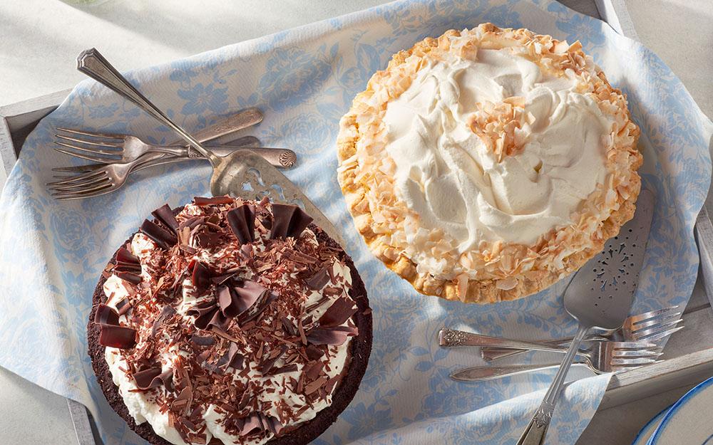 Two pies on top of a fabric-covered tray.