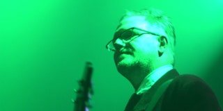 Cardiacs’ Tim Smith on stage bathed in green light