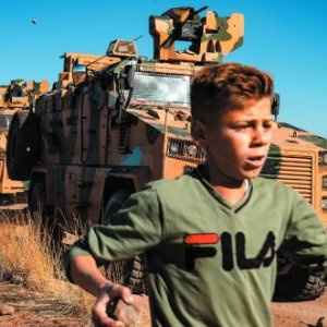 Get out! Young Kurds confront a Turkish military vehicle on patrol in northern Syria after Turkey's invasion. Delil Souleiman/AFP/Getty