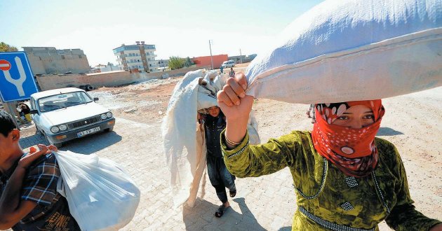 Syrian Kurds seek refuge in Turkey, after fleeing Islamic State  ​which for months laid siege to their hometown Kobani in 2014. Gail Orenstein/Zuma/Alamy