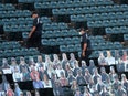 Cardboard cutout fans in the seats of a baseball stadium.