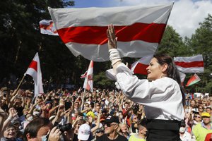 FILE In this file photo taken on Sunday, Aug. 2, 2020, Sviatlana Tsikhanouskaya, candidate for the presidential elections greets people waving old Belarus flags during a meeting to show her support , in Brest, 326 km (203,7 miles) southwest of Minsk, Belarus.