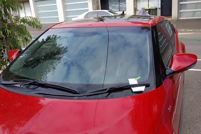  Red car with an infringement notice held under the windscreen wiper