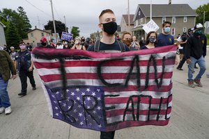 A protester holds a flag during a Black Lives Matter protest Tuesday, Sept. 1, 2020, in Kenosha, Wisconsin.