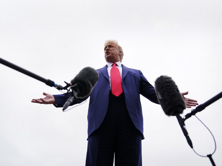 President Donald Trump speaking in to two microphones photographed from below 