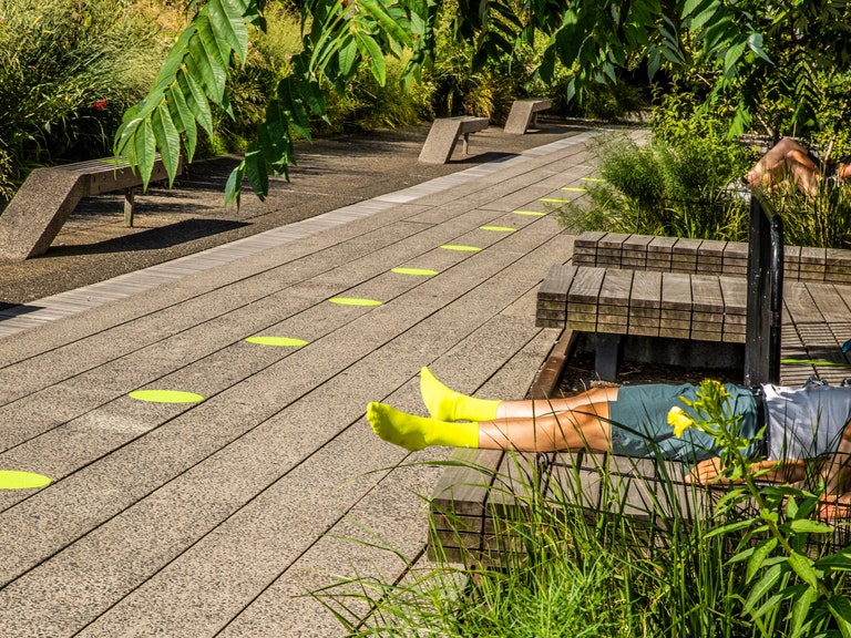 Person laying down in brightly colored socks on High Line.