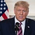 President Donald Trump speaking at a podium in front of a painting of George Washington