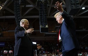 President Donald Trump opens his arms to Rush Limbaugh as he arrives to speaks during a rally at Show Me Center, Monday, Nov. 5, 2018, in Cape Girardeau, Missouri.