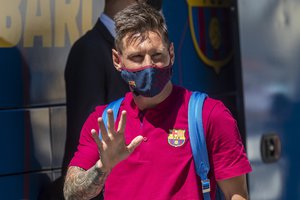 Lionel Messi waves as he arrives to the team hotel in Lisbon, Portugal