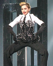 Madonna in an elaborate bustier and suit, posing onstage
