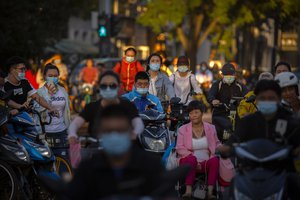 People wearing face masks to protect against the coronavirus cross an intersection in Beijing, Wednesday, Sept. 16, 2020