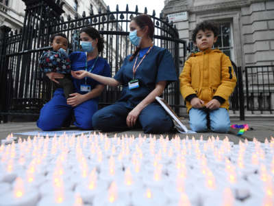 People turn on electric tealights during a vigil