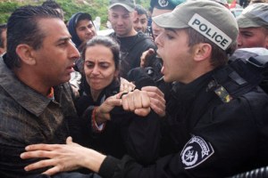 Israeli riot police argue with Palestinian and Jewish citizens of Israel protesting against racism outside a polling station in Um al-Fahem during the Israeli elections, 10 February 2009. (Oren Ziv/ActiveStills) 