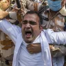 A person is detained by Indian paramilitary soldiers in New Delhi during a protest against the gang rape and cremation of a woman.