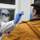 A medical worker tests a man for COVID-19 at a testing site in Cologne, Germany.