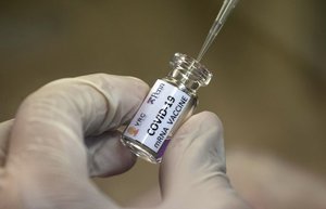 A lab technician extracts a portion of a COVID-19 vaccine candidate during testing at the Chula Vaccine Research Center, run by Chulalongkorn University in Bangkok, Thailand, Monday, May 25, 2020.