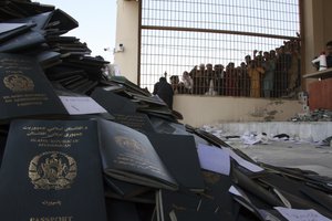 Afghans wait to collect their passports with Pakistani visas inthe city of Jalalabad east of Kabul, Afghanistan