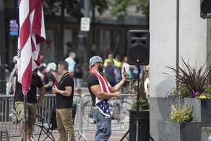 File - Proud Boys stand next to Joey Gibson at a Patriot Prayer and Solidarity Against Hate demonstrations 2017 rally in Seattle, August 13, 2017.